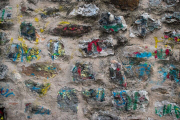 Colourful painted grafiti on a weathered stone wall