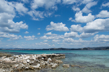 Fototapeta na wymiar Beautiful and calm seascape with transparent sea water and white clouds summer time concept, calm landscape, vacation in Dalmatia, Croatia