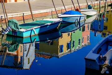 Fototapeta na wymiar refleciotn of colorful houses in a canal on the island of burano near venice, italy