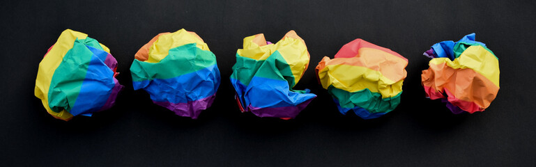 Paper balls made of wringled rainbow colored paper, concept for lgbtq+ communities celebrations in...
