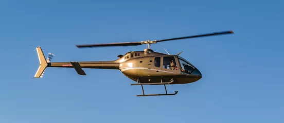 Foto op Plexiglas Helikopter Helikopter die over blauwe hemel vliegt