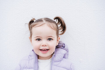 portrait of beautiful caucasian two year old baby girl smiling over white background. childhood