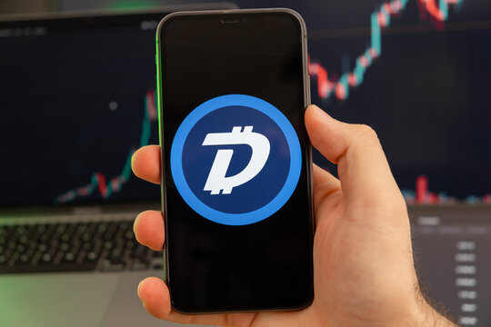 DigiByte DGB app of cryptocurrency stock market analysis on the screen of mobile phone in man hands and growing charts trading data on the background, February 2022, San Francisco, USA. 