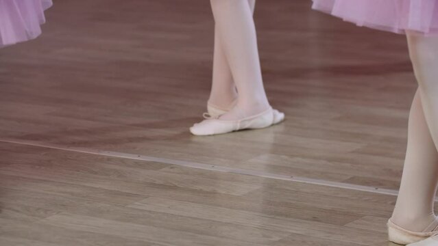 Ballet training - little girls in pink dresses jumping on the spot