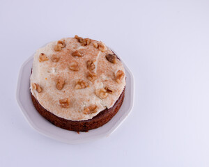 Carrot Cake with cream cheese frosting and walnuts on  plate isolated on left side white background