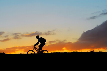 Obraz na płótnie Canvas mountain rider biker on sunset landscape