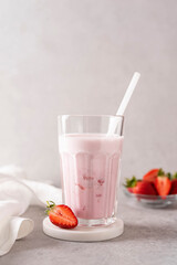 strawberry milkshake with berry pieces in a glass, close-up