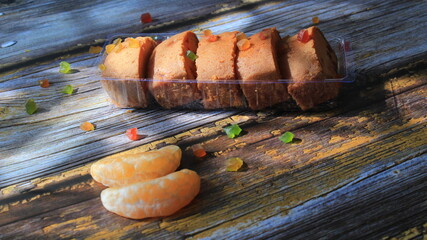 Homemade tutti frutti candied fruit sponge cake on table and colorful background for Christmas