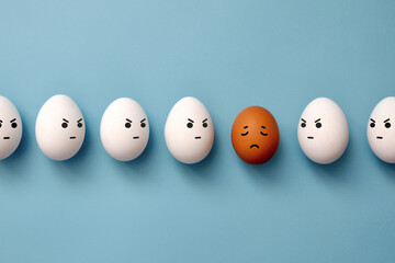 The white eggs stare maliciously at the sad brown egg. Racial discrimination