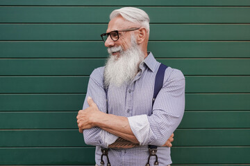 Portrait of trendy hipster senior man with green background