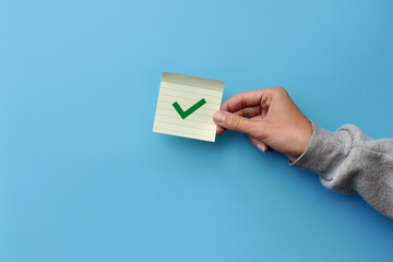 A tick on the sticker in the person's hand. Selection Symbol