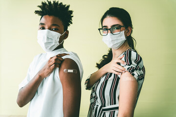Diverse group of people showing COVID-19 vaccine bandage merrily in concept of coronavirus vaccination program to vaccinate citizen .
