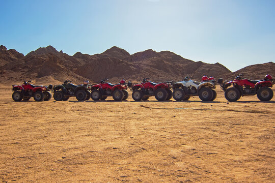 ATVs on Egyptian sand desert near mountains. Quad bike in Nabq protected area, Sharm El Sheikh, Sinai, Egypt. Safari, egyptian excursion, off-road ATV adventures in a desert