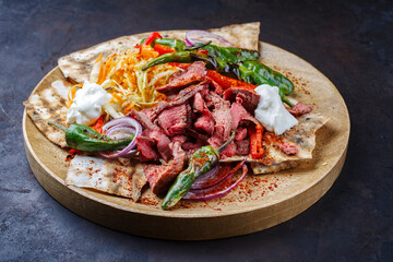 Traditionelles griechisches Gyros vom Rindfleisch mit Karottensalat, Joghurt und Fladenbrot serviert als close-up auf einer rustikalen Holz Board