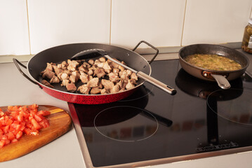 Prepared from a sauté onion, tomato and pepper for a paella, in the kitchen of a house.