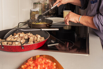 Prepared from a sauté onion, tomato and pepper for a paella, in the kitchen of a house.
