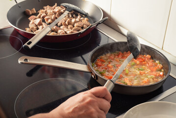 Prepared from a sauté onion, tomato and pepper for a paella, in the kitchen of a house.