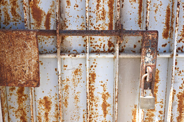 rusty gate with closed padlock