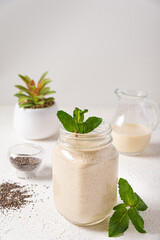 Obraz na płótnie Canvas vanilla protein shake glass jar mint. delicious vanilla protein breakfast shake in a mason jar mint leaf