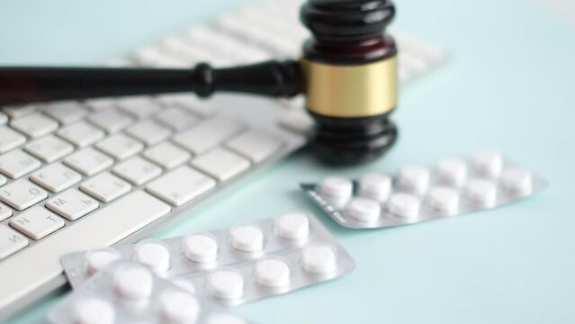 Gavel and pills on a blue background. Medical crime. Judge gavel and pills. Litigation Medicine-Related Healthcare in Pharmaceuticals. Law in medicine