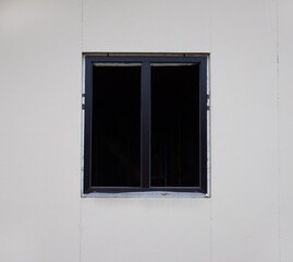 a dark window without glass installed in the house against a light wall. repair and renovation.