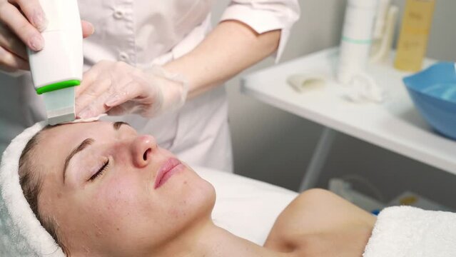 Ultrasound cosmetology scrubber. Face cavitation procedure. Salon skincare treatment. Professional peeling hardware. Electric spa equipment. Medicine patient device. Removal acne video