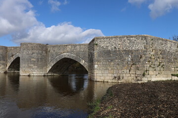 Fototapeta premium Le vieux pont sur la rivière Gartempe, pont en pierre du 13eme siècle, village de Saint Savin sur Gartempe, département de la Vienne, France