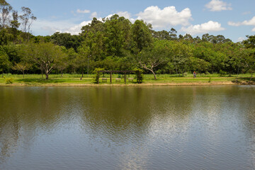 Paisagem de um parque muito arborizado e um lago, na cidade de Goiânia. Parque Leolidio di Ramos...