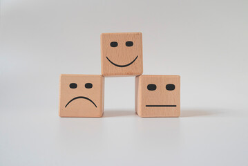 Face icons on wooden cubes.
Customer service assessment and technology customer support concept.Business service rating.
