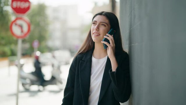 Young hispanic girl smiling confident talking on the smartphone at street