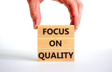Focus on quality symbol. Concept words Focus on quality on blocks on beautiful white table white background. Businessman hand. Business, focus on quality concept. Copy space.