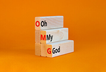 OMG oh my god symbol. Concept words OMG oh my god on wooden blocks on a beautiful orange table,...