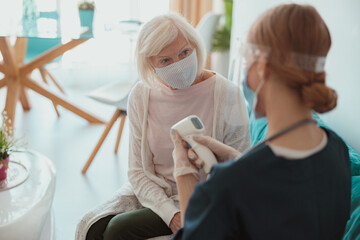 Healthcare specialist checking elderly patient at home