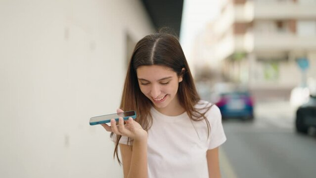 Young hispanic girl talking on the smartphone walking at street