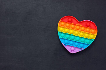 Rainbow Pop it fidget toy in the shape of a heart.