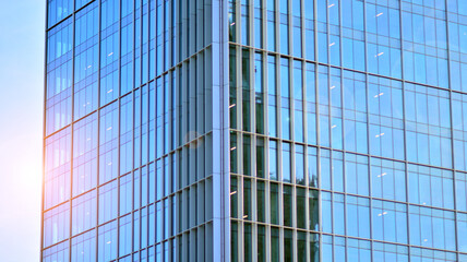 Fototapeta na wymiar Urban abstract - windowed wall of office building. Detail shot of modern business building in city. Looking up at the glass facade of a skyscraper.