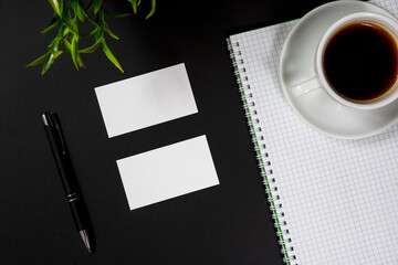 White blank business card stationery on black desktop with office supplies