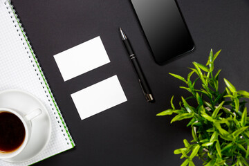 White blank business card stationery on black desktop with office supplies
