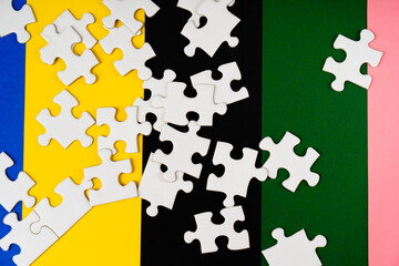 Missing jigsaw puzzle pieces. Business concept. Fragment of a folded white jigsaw puzzle and a pile...