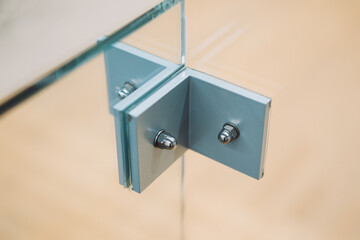 photograph of a glass partition fastening element with a blurred background