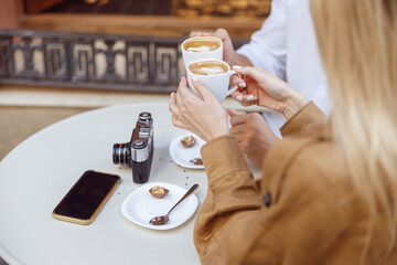 Close-up photo of woman and man drinking coffee