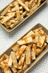 Marinated tofu strips with ginger, garlic, soy sauce and honey marinate on plates.