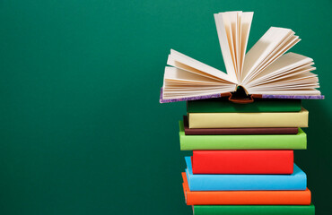 Composition with vintage old hardback books, diary, fanned pages on wooden deck table