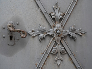Schmiedeeiserner Schmuck auf einer alten Eisentür als Lilienmuster