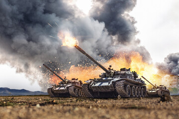 Group of main battle tanks with a city on fire on the background. One tank firing a shell from the...