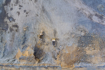 Aerial view in a quarry, excavator and dump truck during the loading of mined rock.