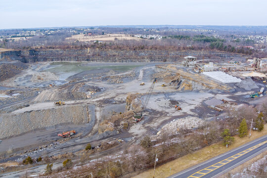 Aerial view of the open pit loader loading gravel into stone jaw crusher in open-pit quarry development