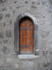 Fototapeta na wymiar Mittelalterliche Tür an einem gotischen Türeingang mit Beschlägen aus Schmiedeeisen aus dem Jahr 1567