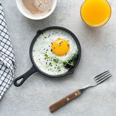fried eggs in a frying pan, cup of coffe, orange juice