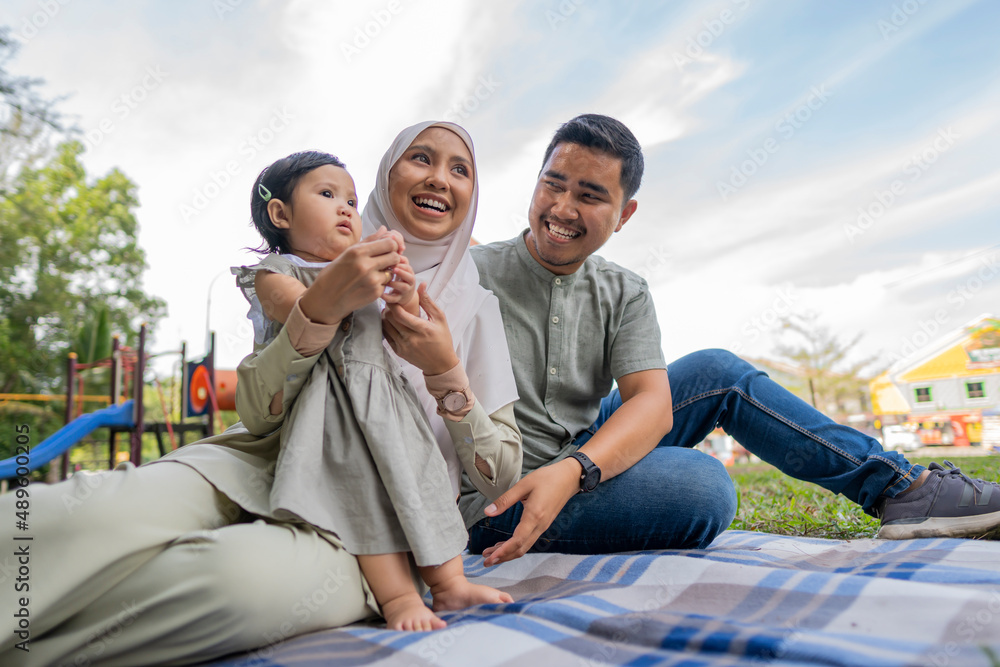 Wall mural happy muslim family have a picnic outdoor